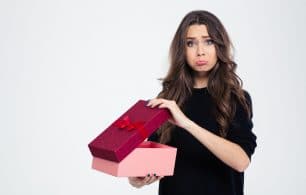 Disappointed woman opening present