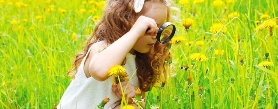 Girl looking through magnifying glass