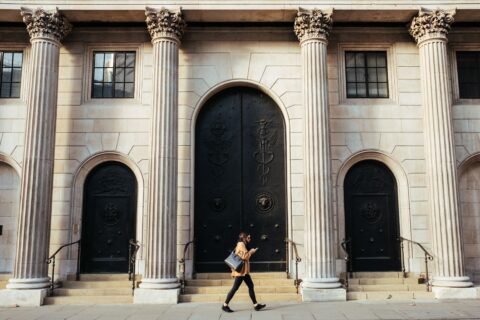 woman walking in front of building