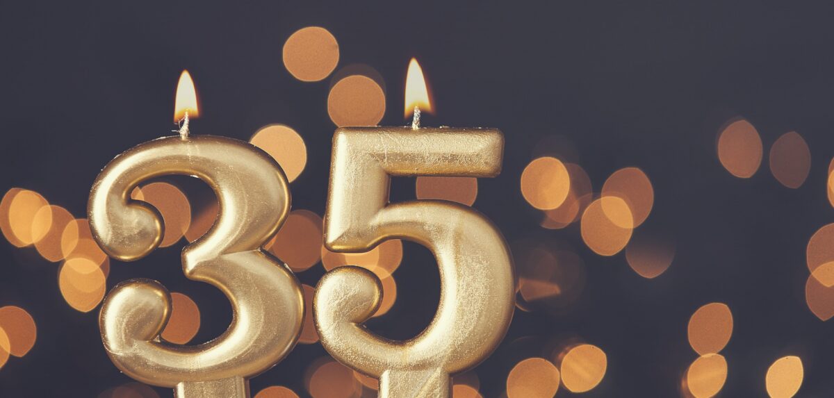 Gold number 35 celebration candle against blurred light background