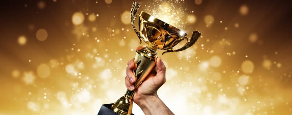 Man holding up a gold trophy cup