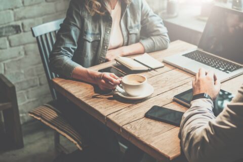 Businessman and businesswoman sitting at table in coffee shop