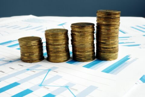 Profit increase. Stacks of coins and financial report.