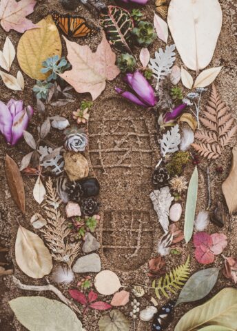 footprint in sand with flowers
