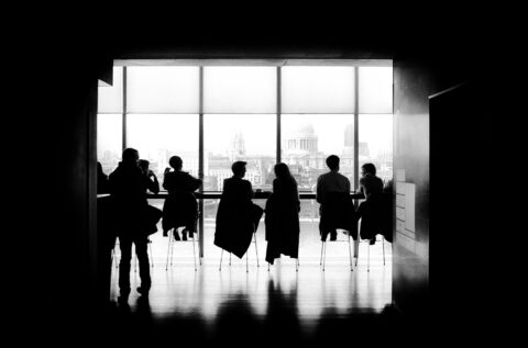 Black and white photo of people at boardroom table