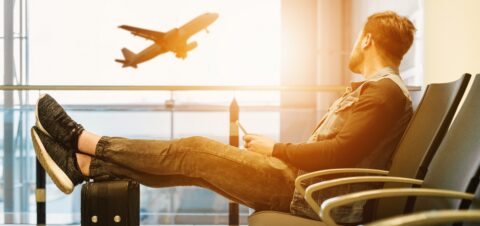 Man in airport watching plane take off