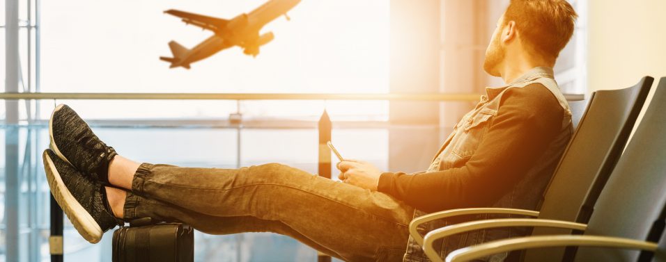 Man in airport watching plane take off