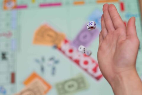 female hand throws dice in a board game close up