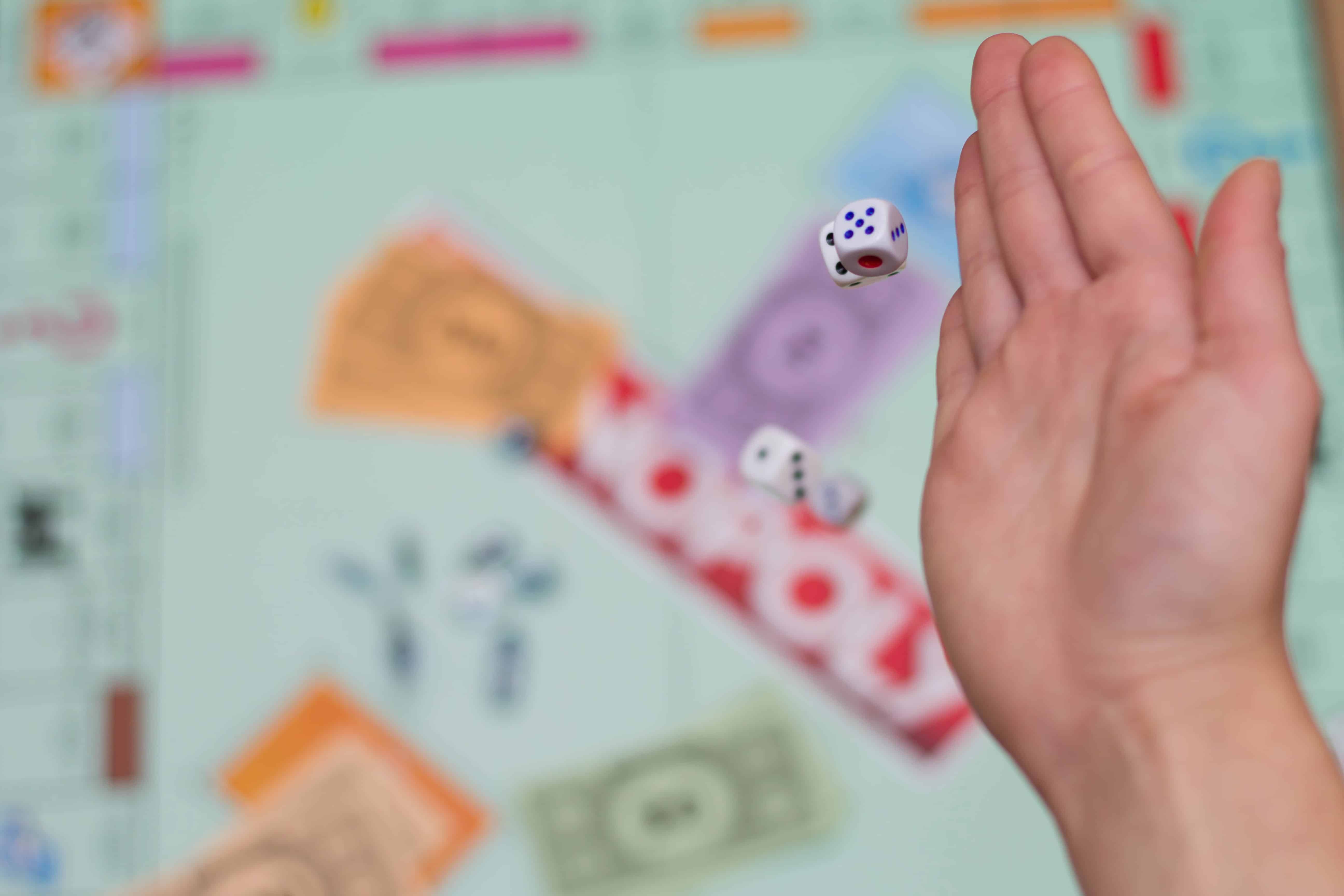 female hand throws dice in a board game close up FundCalibre