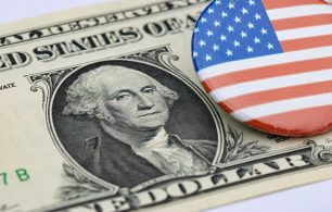 US Dollar bill in the background with a US flag badge on top of it