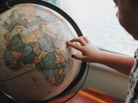 Colourful globe showing Africa with child pointing to country out of shot