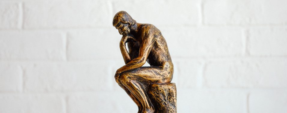A statues of a man worrying about the world