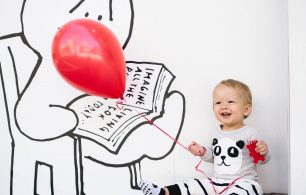 happy baby with one red balloon