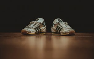 2 old trainers on a wooden floor