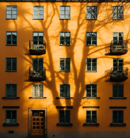 Flats and housing in an orange building with shadow on