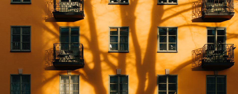 Flats and housing in an orange building with shadow on