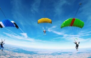 3 parachutes high in the blue sky