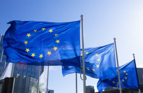 3 European flags up flagpoles