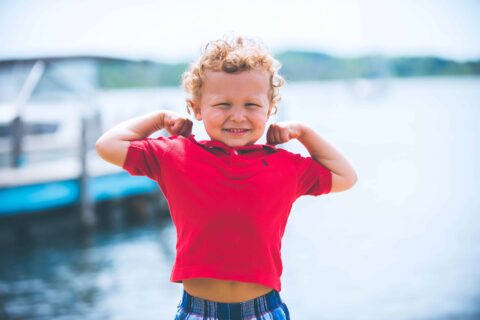 young child flexing his muscles