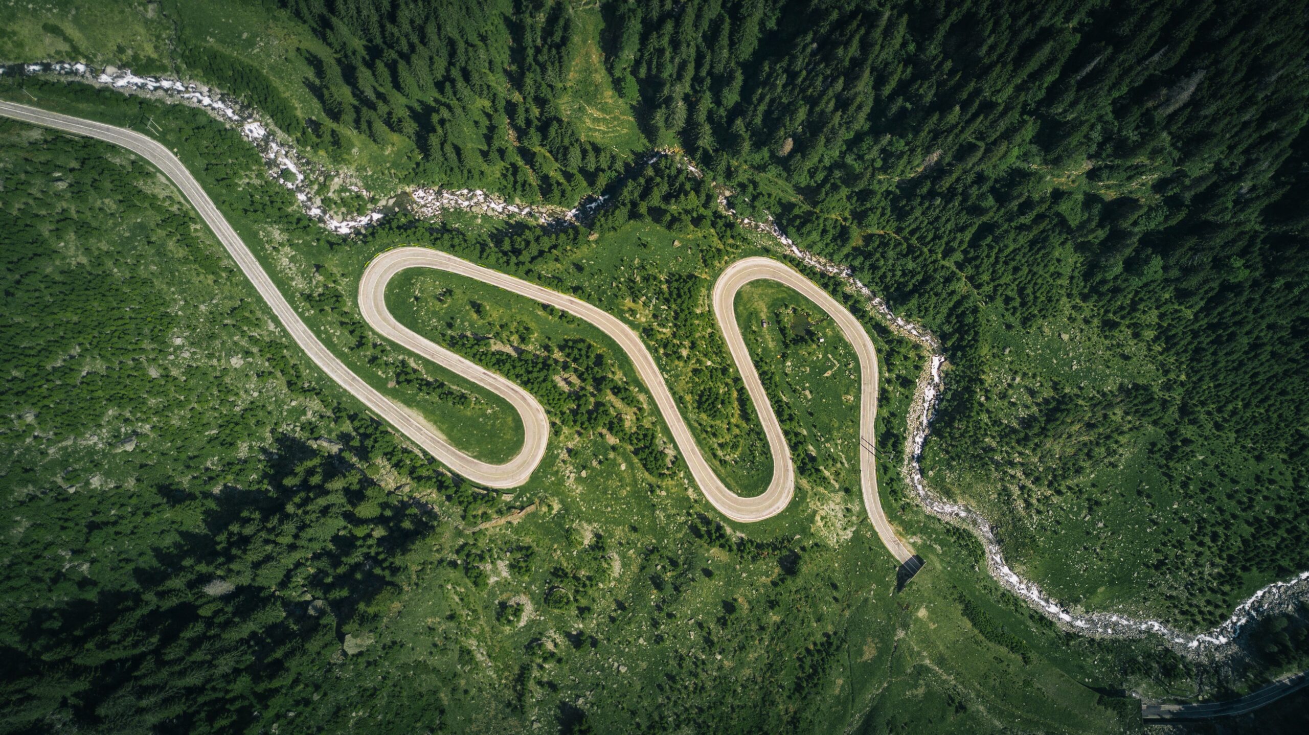 a long and winding road through green fields