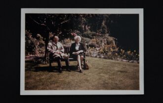 a photo of 2 old people sitting in retirement on a bench