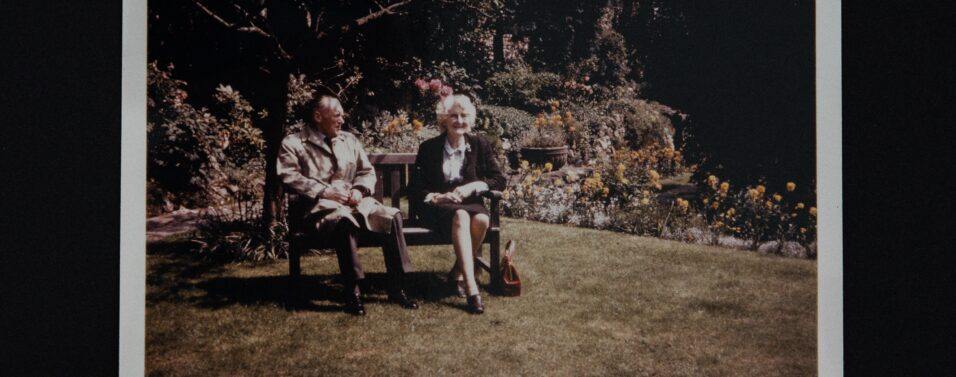 a photo of 2 old people sitting in retirement on a bench